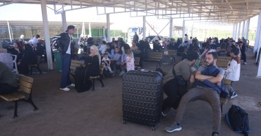Syrian nationals wait at the Cilvegözü border crossing to cross into Syria, Hatay, southern Türkiye, Oct. 28, 2025. (IHA Photo)