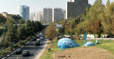 Sculptures in the shape of whales stand near a road as commuters drive toward high rise buildings in Tehran, Iran, Oct. 4, 2025. (AFP Photo)