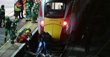 Police officers and members of the emergency services search the track beneath a train at Huntingdon station after a mass stabbing on a London-bound train in eastern England, in Cambridgeshire, England, Nov. 1, 2025. (AFP Photo)