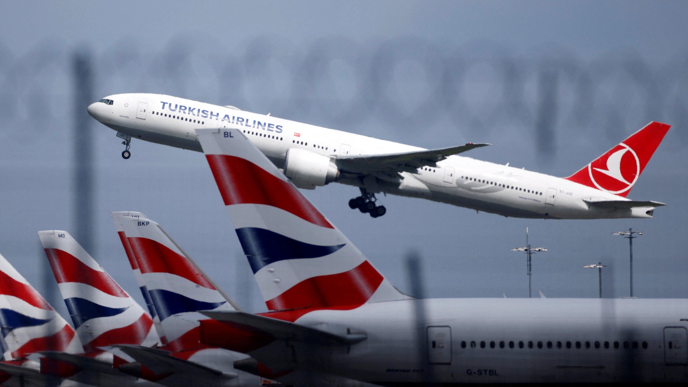 A Turkish Airlines Boeing 777 takes off past parked British Airways aircraft at Heathrow Airport, London, U.K., May 17, 2021. (Reuters Photo)