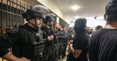 Armed and masked IDF reservists from the &quot;100 force&quot; stand in front of Israeli police officers blocking the Beit Lid base gate following abuse allegations, Kfar Yona, Israel, July 29, 2024. (Getty Images Photo)