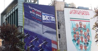An anti-Israeli and anti-U.S. billboard (L), featuring a message reading &quot;Behind every star, there is a crime,&quot; is displayed on a building, Palestine Square, Tehran, Iran, Nov. 3, 2025. (EPA Photo)