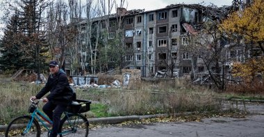 A resident rides a bicycle near apartment buildings damaged by a Russian military strike, amid Russia&#039;s attack on Ukraine, in the frontline town of Kostiantynivka in the Donetsk region, Ukraine, Nov. 1, 2025. (Reuters Photo)