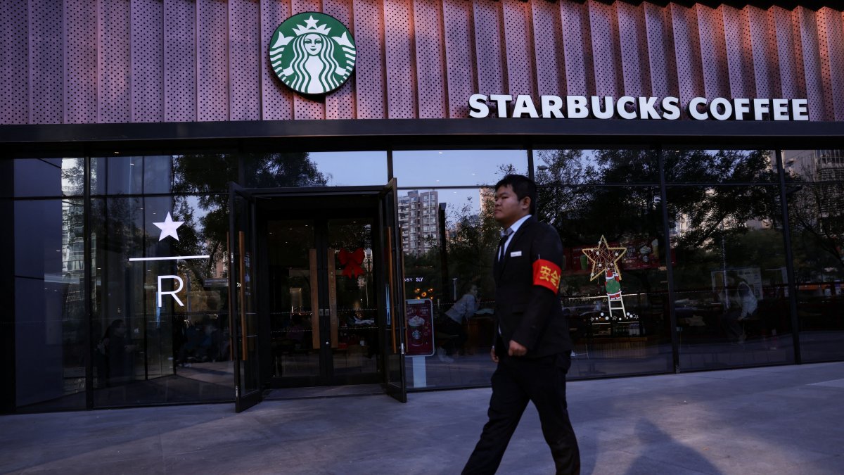 A security guard walks past a Starbucks coffee shop in Beijing, China, Nov. 4, 2025. (Reuters Photo)