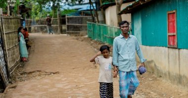 Mohammed Faruq holds the hand of his daughter Nahima Bibi, 9, as they walk along the refugee camp, Cox&#039;s Bazar, Bangladesh, Aug. 17, 2025. (Reuters Photo)