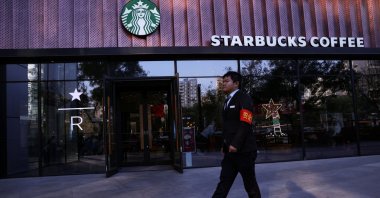 A security guard walks past a Starbucks coffee shop in Beijing, China, Nov. 4, 2025. (Reuters Photo)