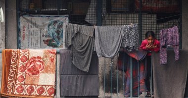 A displaced Palestinian girl reacts while standing next to a railing as she takes shelter at an UNRWA-run school, in Khan Younis, southern Gaza Strip, Palestine, Oct. 9, 2025. (Reuters Photo)