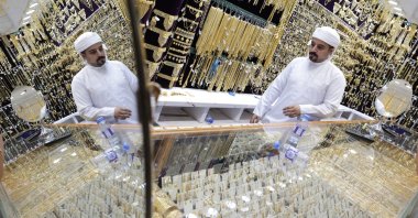 A shop exhibitor shows a gold ornament to a customer at a jewellery shop inside the gold market in Dubai, United Arab Emirates, Oct. 20, 2025. (EPA Photo)