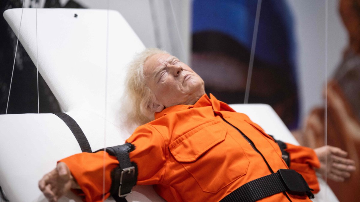 This photograph shows the art piece by British artist Mason Storm called &quot;Saint or Sinner,&quot; depicting U.S. President Donald Trump dressed in an orange prison jumpsuit on a cross, displayed at an exhibition space, Basel, Switzerland, Nov. 3, 2025. (AFP Photo)