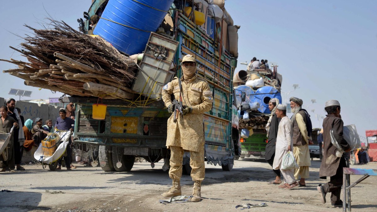 A Taliban security personnel stands guard as deported Afghan refugees from Pakistan arrive at the zero-point border crossing between Afghanistan and Pakistan, Kandahar province, Afghanistan, Oct. 27, 2025. (AFP Photo)