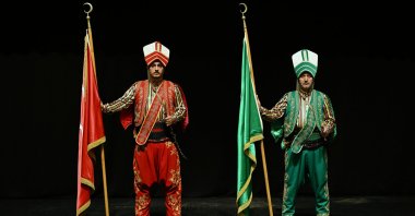 Two members of the Kanuni Mehteran Band hold the ceremonial banner during a performance, Trabzon, northeastern Türkiye, Nov. 4, 2025. (AA Photo)