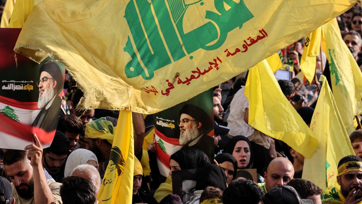 Hezbollah supporters raise the party's yellow flags and pictures of its slain leader, as they mark the first anniversary of his killing, in Beirut, Lebanon, Sept. 25, 2025. (AFP Photo)