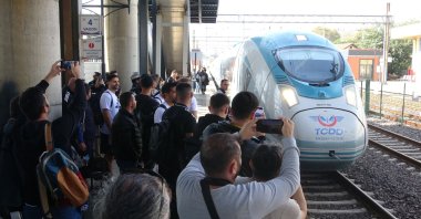 People take a photo of a high-speed train (YHT) carrying football players, Kocaeli, northwestern Türkiye, Oct. 17, 2025. (DHA Photo)