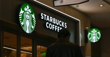A man walks past a Starbucks coffee shop at a mall in Beijing, China, Nov. 5, 2025. (AFP Photo)