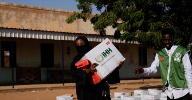 A Sudanese woman carries an aid box distributed by the Humanitarian Relief Foundation (IHH) as part of ongoing relief efforts in conflict-affected regions of Sudan, Oct. 31, 2025. (AA Photo)