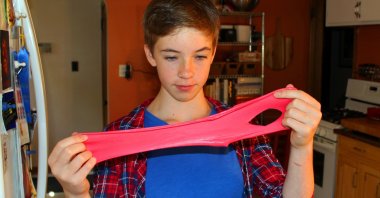 Astrid Rubens demonstrates the elasticity of homemade slime, St. Paul, Minn., U.S., June 21, 2017. (AP Photo)