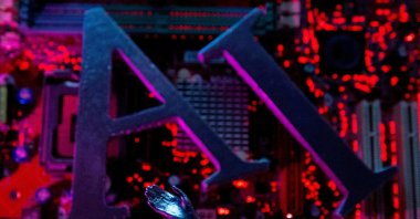 AI letters and robot hand are placed on computer motherboard in this illustration created, June 23, 2023. (Reuters Photo)