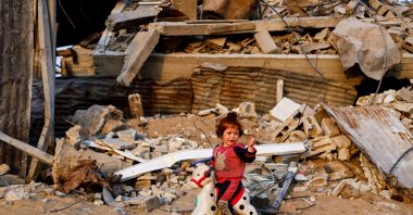 A Palestinian child plays with a toy amid the rubble of destroyed buildings, after a cease-fire between Israel and Hamas, Jabalia, northern Gaza Strip, Palestine, Nov. 6, 2025. (Reuters Photo)