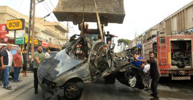 A bulldozer removes the wreckage of a vehicle targeted by an Israeli drone strike in the southern village of Ad Douwayr, near the city of Nabatieh, Lebanon, Nov. 3, 2025. (AFP Photo)