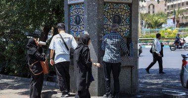 Iranians drink water from a public street fountain in Tehran, Iran, July 22, 2025. (AFP Photo)