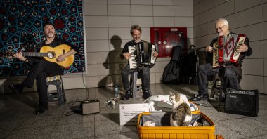Street musicians perform with “Sirkecili,” a cat that often accompanies them, at Sirkeci Marmaray Station in Istanbul, Türkiye, Nov. 8, 2025. (AA Photo)