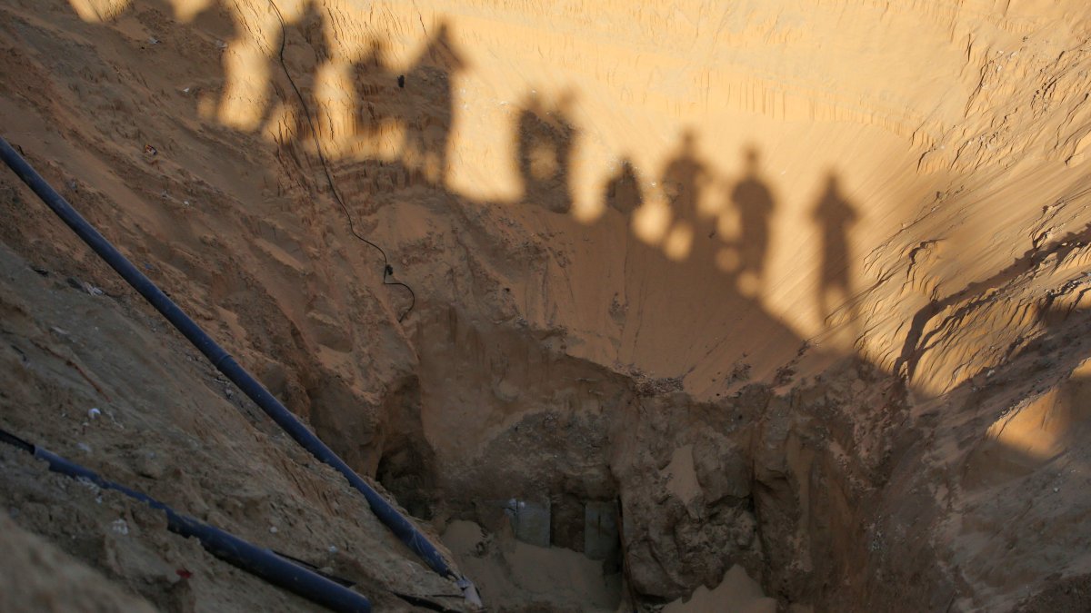 People stand over a tunnel as Hamas search for bodies in an area north of Khan Yunis, southern Gaza Strip, Palestine, Oct. 28, 2025.(AFP Photo)