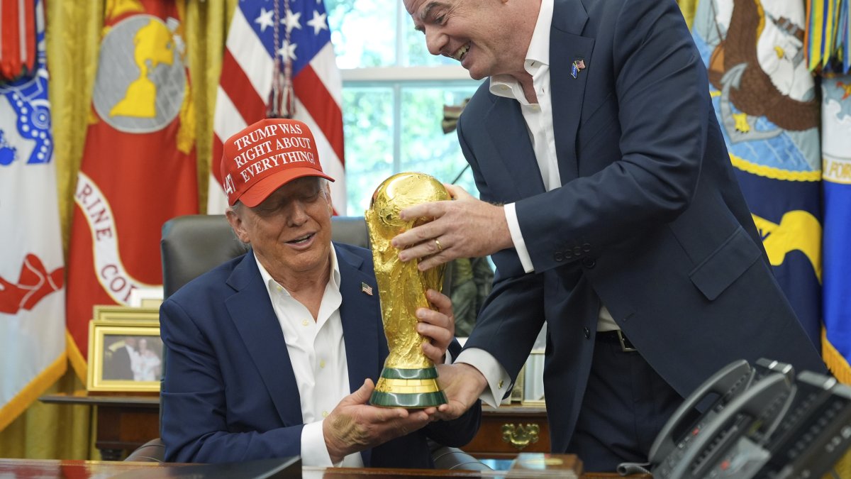 FIFA President Gianni Infantino (R) hands the FIFA World Cup Winners Trophy to President Donald Trump during an announcement in the Oval Office of the White House, Washington, U.S., Aug. 22, 2025. (AP Photo)