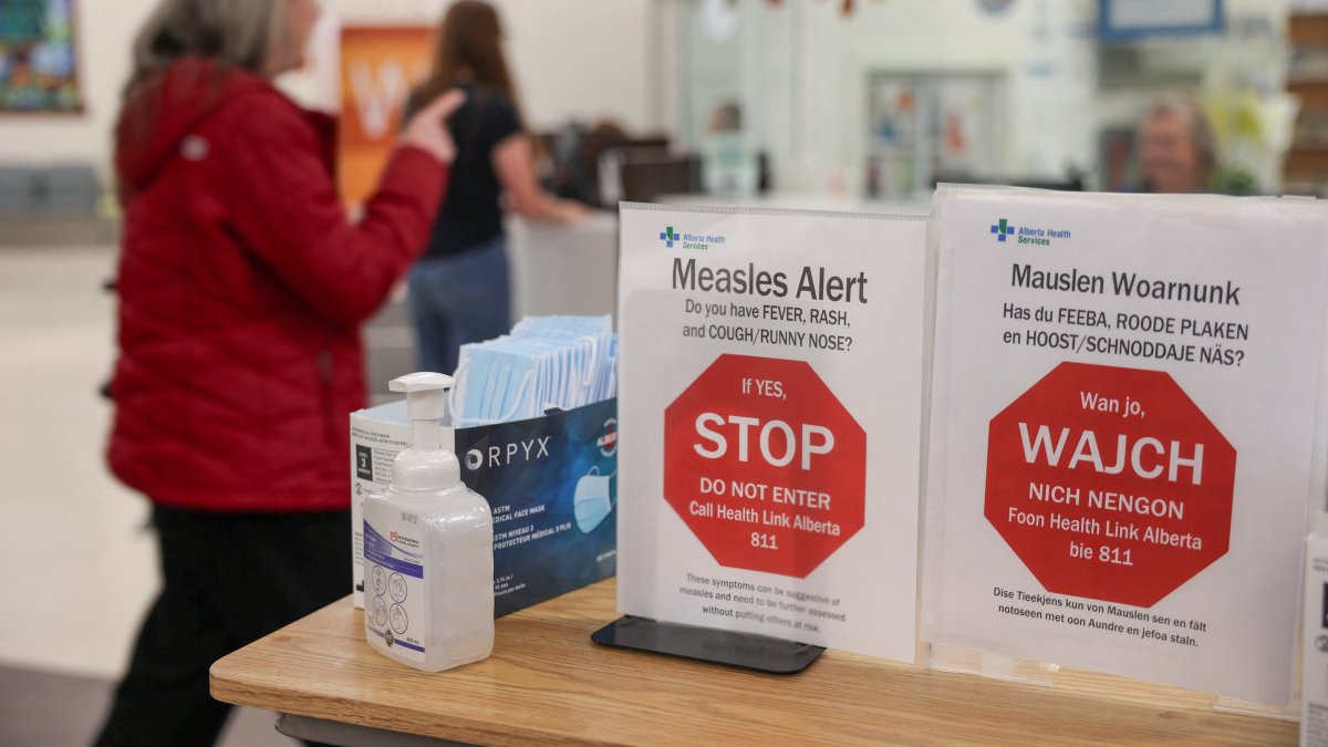 A woman passes by healthy awareness posters related to the measles outbreak during a public health awareness campaign, at the Taber Health Centre, in the largely Mennonite community of Taber, Alberta, Canada, Oct. 27, 2025. (Reuters Photo)