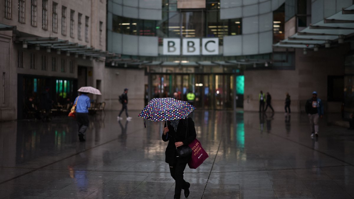 People shelter from the rain outside the entrance to the BBC in London, United Kingdom, Nov. 10, 2025. (AFP Photo)