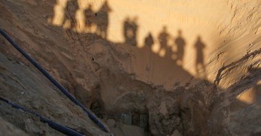 People stand over a tunnel as Hamas search for bodies in an area north of Khan Yunis, southern Gaza Strip, Palestine, Oct. 28, 2025.(AFP Photo)