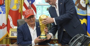 FIFA President Gianni Infantino (R) hands the FIFA World Cup Winners Trophy to President Donald Trump during an announcement in the Oval Office of the White House, Washington, U.S., Aug. 22, 2025. (AP Photo)