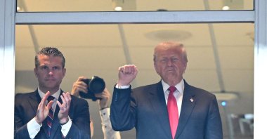 United States Secretary of Defense Pete Hegseth (L) claps while U.S. President Donald Trump holds up his fist during a game between the Detroit Lions and the Washington Commanders at Northwest Stadium, Landover, U.S., Nov. 9, 2025. (AFP Photo)
