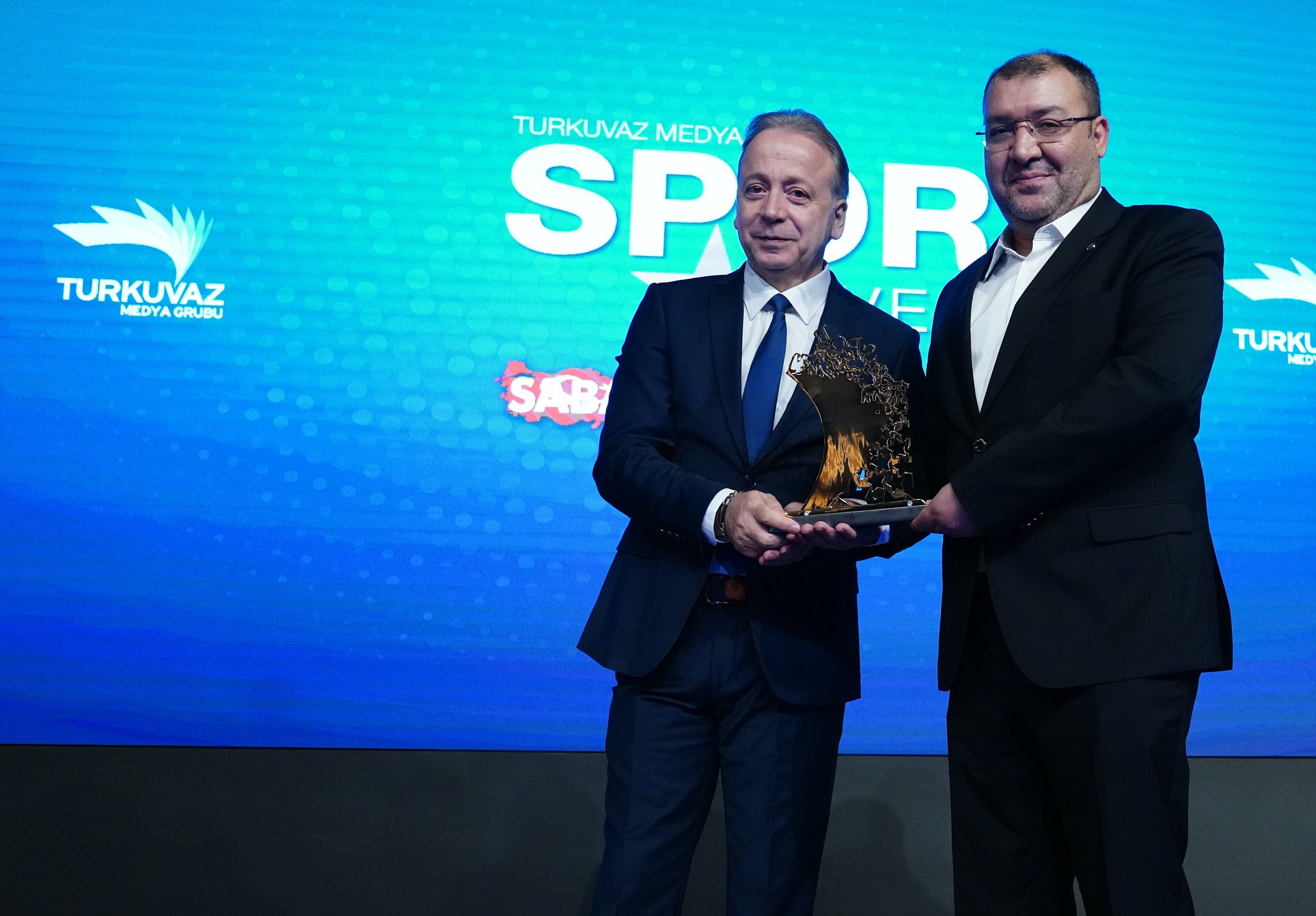 Fotomaç Newspaper Editor-in-Chief Zeki Uzundurukan (L) presents Turkuvaz Digital Publications General Manager Mustafa Yüce with an award during the Turkuvaz Media Sports Summit at Turkuvaz Media Center, Istanbul, Türkiye, Nov. 11, 2025. (Courtesy of Turkuvaz Media)