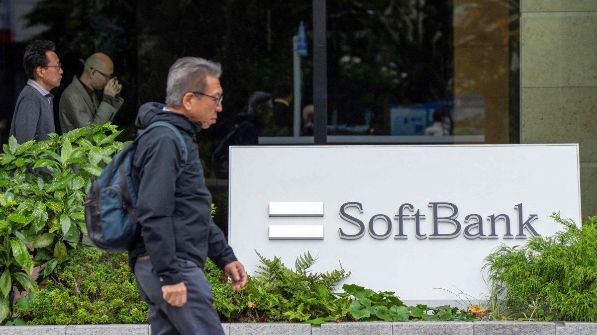 Pedestrians walk past signage outside the building where the SoftBank Group headquarters is located, Tokyo, Japan, Nov. 11, 2025. (AFP Photo)