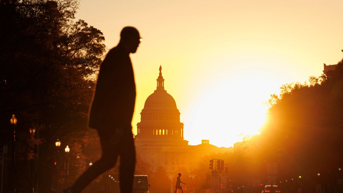Pedestrians walk along Pennsylvania Avenue near the U.S. Capitol during sunrise in Washington, U.S., Nov. 5, 2025. (AFP Photo)