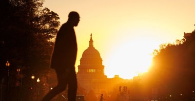 Pedestrians walk along Pennsylvania Avenue near the U.S. Capitol during sunrise in Washington, U.S., Nov. 5, 2025. (AFP Photo)