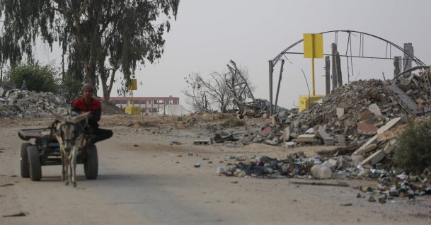 A Palestinian man rides on a cart pulled by a donkey near a concrete block (back) marking the "Yellow Line" drawn by the Israeli military in Bureij, central Gaza Strip, Palestine, Nov. 4, 2025. (AFP Photo)