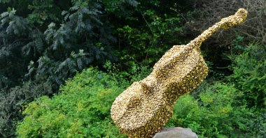 "Celloswarm," a bronze, steel and gold leaf installation by Bill Woodrow in the free public English Gardens area, north London, U.K., July 5, 2019. (Shutterstock Photo)