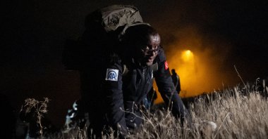 A participant in Anadolu Agency’s 28th edition of the War Journalism Training Program carries gear to the Elmadağ Police Academy Training Field for ambush and night navigation exercises, Ankara, Türkiye, Nov. 11, 2025. (AA Photo)