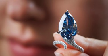 A staff member shows a 9.51-carat vivid blue diamond, known as &quot;The Mellon Blue,&quot; during its presentation at Christie’s auction house, Geneva, Switzerland, Nov. 7, 2025. (AFP Photo)