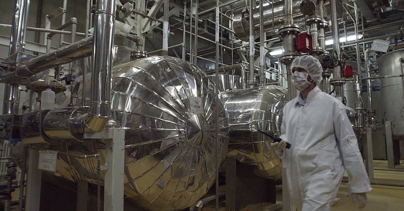 An Iranian security official in protective clothing walks through part of the Uranium Conversion Facility just outside the city of Isfahan, Iran, March 30, 2005. (AP Photo)