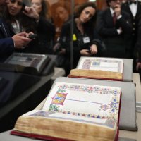 Reporters look at the 15th-century Borso D&#039;Este Bible, comprising two illuminated manuscripts, after its unveiling at the Italian Senate as part of the Vatican&#039;s Holy Year celebrations, Rome, Italy, Nov. 13, 2025. (AP Photo)
