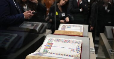 Reporters look at the 15th-century Borso D&#039;Este Bible, comprising two illuminated manuscripts, after its unveiling at the Italian Senate as part of the Vatican&#039;s Holy Year celebrations, Rome, Italy, Nov. 13, 2025. (AP Photo)