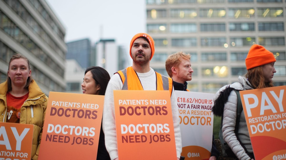 NHS resident doctors hold placards outside St. Thomas' Hospital as thousands strike over pay, London, U.K., Nov. 14, 2025. (AP Photo)