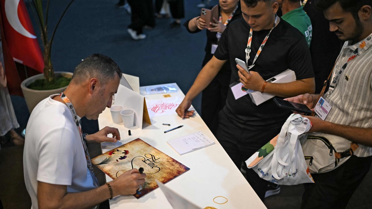 Turkish calligraphy artist Yıldırım Beyazıt Yaylak draws at Türkiye's pavilion during the COP30 U.N. Climate Change Conference in Belem, Para State, Brazil, Nov. 13, 2025. (AFP Photo)