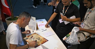 Turkish calligraphy artist Yıldırım Beyazıt Yaylak draws at Türkiye&#039;s pavilion during the COP30 U.N. Climate Change Conference in Belem, Para State, Brazil, Nov. 13, 2025. (AFP Photo)