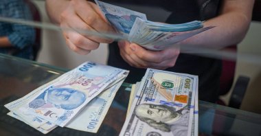 A man at an exchange office counts Turkish lira banknotes in Ankara, Türkiye, Jan. 13, 2022. (Reuters Photo)