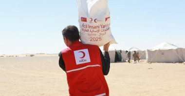 A Turkish Red Crescent (Kızılay) member carries essential food supplies to displaced families in ed-Debbe, northern Sudan, Nov. 15, 2025. (AA Photo)