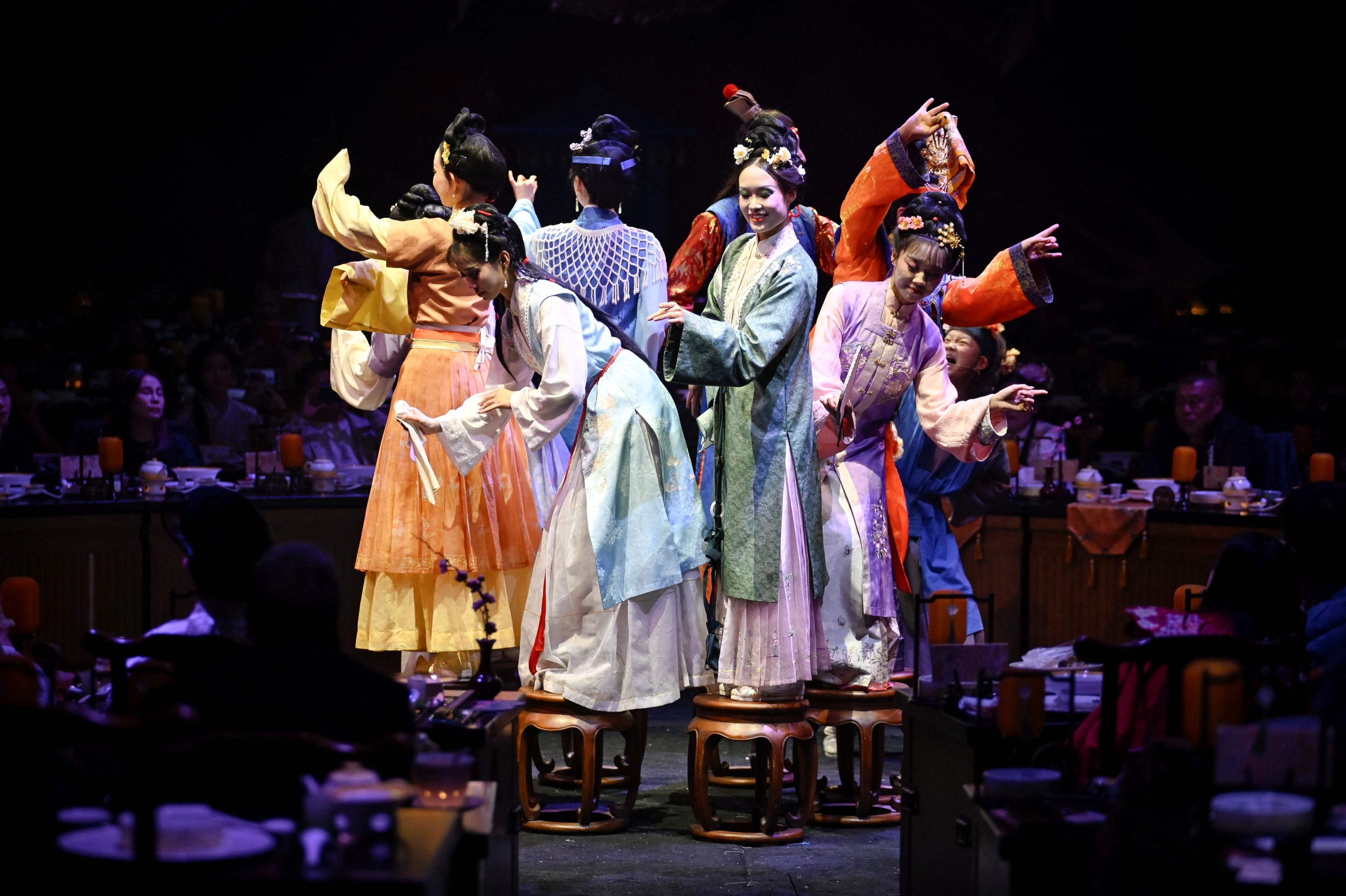 Artistas vestidos con ropas tradicionales chinas actúan mientras los clientes disfrutan de sus comidas en un restaurante teatral, Beijing, China, el 5 de noviembre de 2025. (Foto AFP)