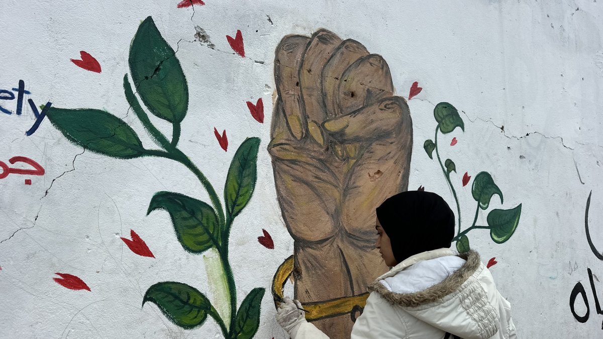 Gaza artists paint 'We Will Rebuild' on surviving wall